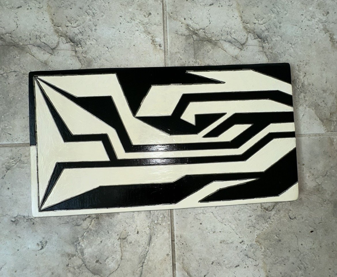 Interplay, an engraved wood panel with black and cream acrylic paint and a stainless steel rod inlay