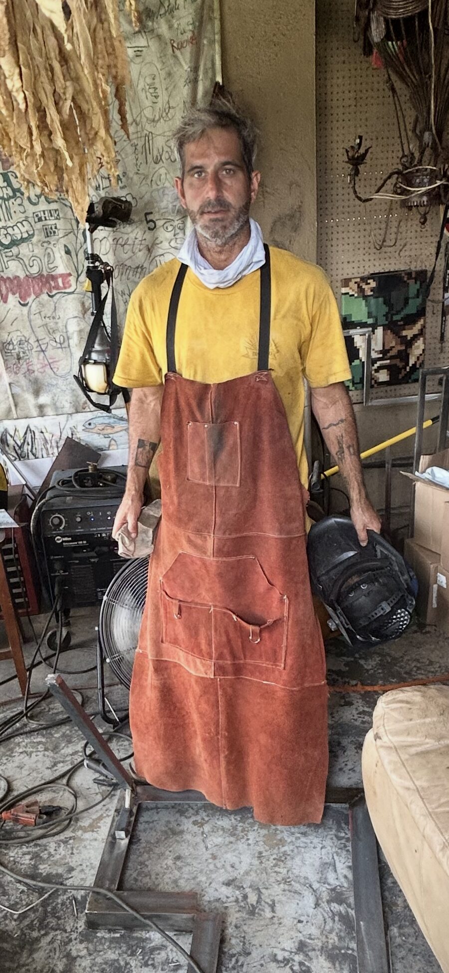 Matthew Ball in a leather welding apron in his workshop