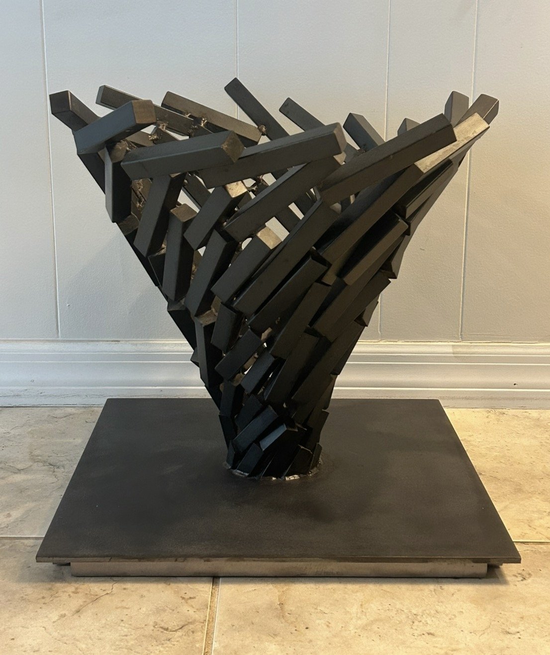 Vortex 1, a carbon steel sculpture of angular blocks rotating and expanding upward from a steel plate base